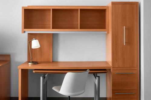 a wooden desk with a chair and a lamp at TownePlace Suites by Marriott Carlsbad in Carlsbad