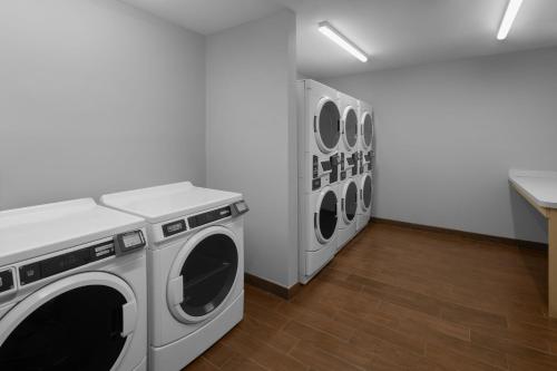 a laundry room with three washing machines in it at TownePlace Suites by Marriott Carlsbad in Carlsbad