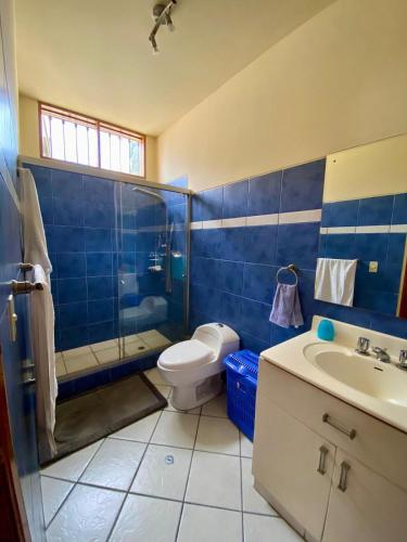 a blue bathroom with a toilet and a sink at Casa Vaí Cieneguilla with a pool in Cieneguilla