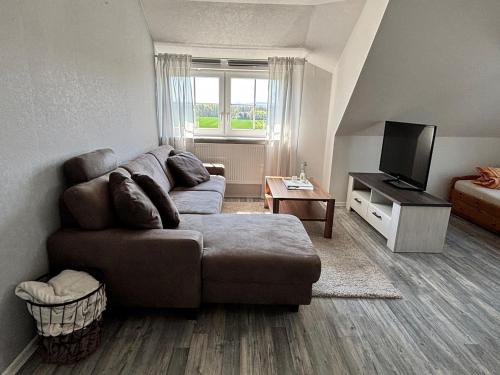 a living room with a couch and a television at Ruhige Ferienwohnung mit Waldblick in Horn-Bad Meinberg