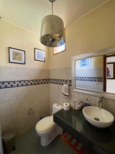 a bathroom with a sink and a toilet and a mirror at Casa Vaí Cieneguilla with a pool in Cieneguilla