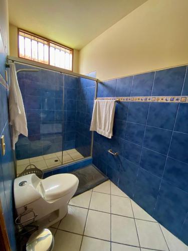a blue tiled bathroom with a toilet and a sink at Casa Vaí Cieneguilla with a pool in Cieneguilla