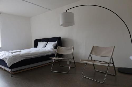 a bedroom with two chairs and a bed at Charming Studio 111 - Krone in Aarau