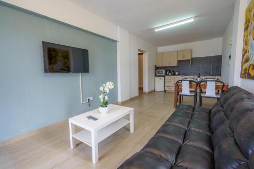 a living room with a couch and a table at Pernera One Suites in Pernera Protaras in Paralimni