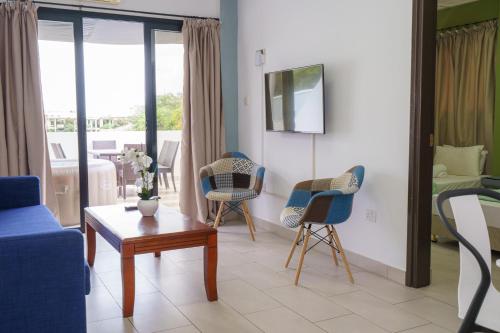 a living room with a blue couch and chairs at Pernera One Suites in Pernera Protaras in Paralimni