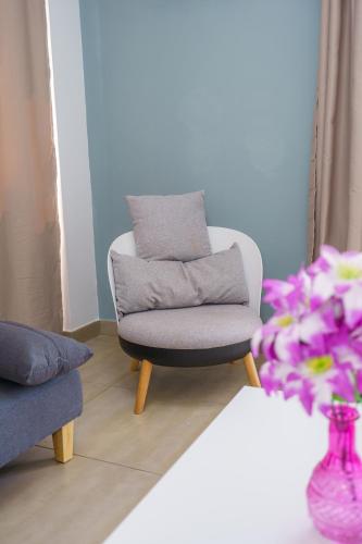a chair in a living room with a purple vase at Pernera One Suites in Pernera Protaras in Paralimni