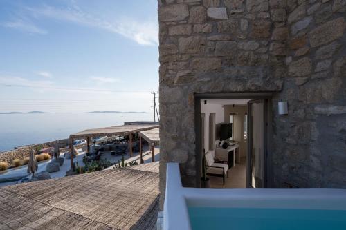 a building with a balcony with a view of the ocean at Rocabella Mykonos Hotel in Agios Stefanos