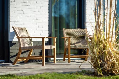 two chairs and a table on a patio at Eilandhotel Texel - Nieuw geopend hotel in De Cocksdorp