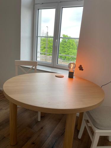 a wooden table in a room with a window at Living 7 Apartments in Neufahrn in Niederbayern