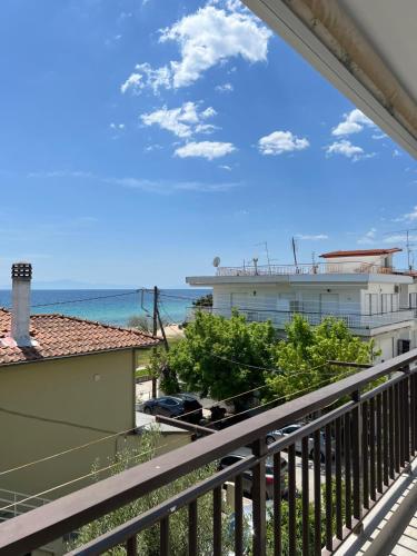 a balcony with a view of a building and the ocean at Sunset Apartments in Paralia Dionysiou