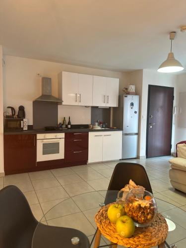 une cuisine avec une table avec un bol de fruits dessus dans l'établissement Appartement situé en ville, à Ajaccio