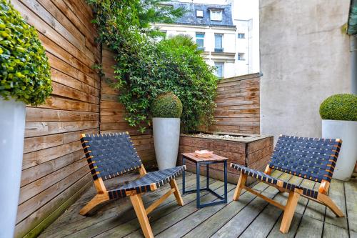 deux chaises et une table sur une terrasse dans l'établissement Chic Terrasse a 5min des Champs-Elysees with AC, à Paris
