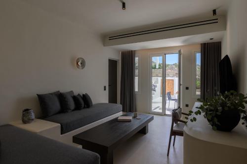 a living room with a couch and a table at Rocabella Mykonos Hotel in Agios Stefanos