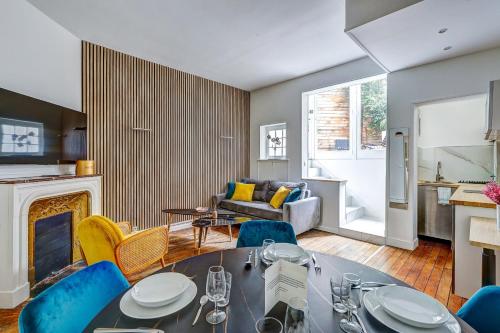 un salon avec une table et des chaises et une cheminée dans l'établissement Chic Terrasse a 5min des Champs-Elysees with AC, à Paris