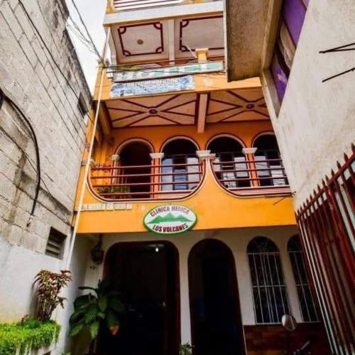 a yellow building with a balcony on top of it at Hotel Henderson in San Pedro La Laguna