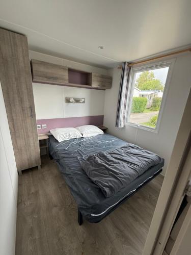 une petite chambre avec un lit et une fenêtre dans l'établissement Mobil home, à Saint-Nic