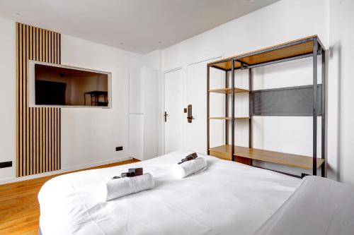 une chambre avec un lit blanc et une fenêtre dans l'établissement Studio Neuf et Climatise sur les Champs Elysees, à Paris