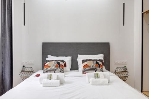 a bedroom with a large white bed with two pillows at Charmant logement renove proche des champs with AC in Paris