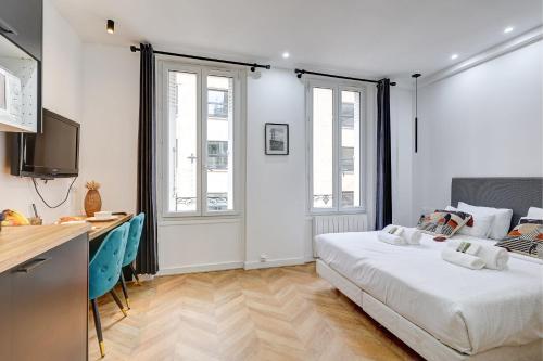 une chambre avec un lit et un bureau et deux fenêtres dans l'établissement Charmant logement renove proche des champs with AC, à Paris