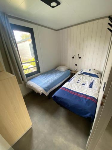 a small bedroom with a bed and a window at Cottage chalet standing gîte l'Edune résidence de vacances location wifi inclus piscine couverte chauffée proche de la plage in Jullouville-les-Pins