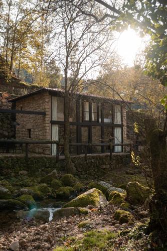 a stone house in the middle of a stream at Quinta do Fradinho - Casa do Rio in Soajo