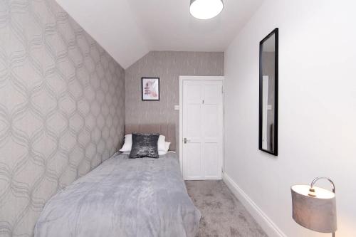 a bedroom with a bed and a wall at Modern 3 Bedroom Home in Central Rugby w Parking in Rugby