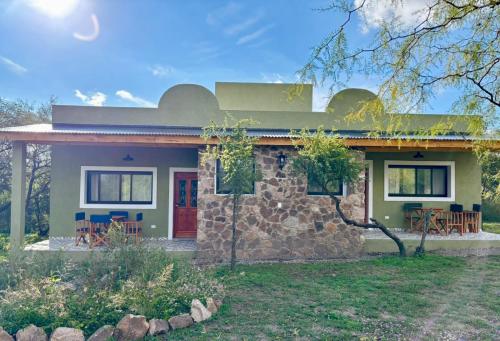 een stenen huis met een rode deur bij La Corrida hospedaje in San Javier