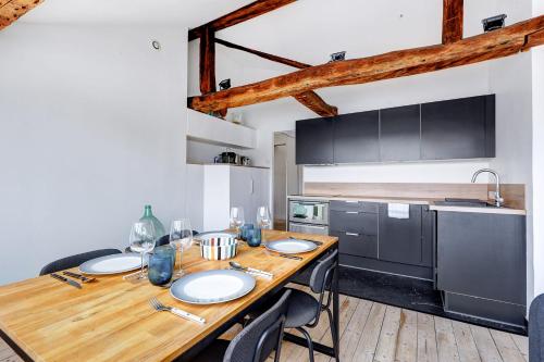 une cuisine avec une table en bois et des plaques de cuisson. dans l'établissement Un Eclat de Lumiere en Plein Paris, à Paris