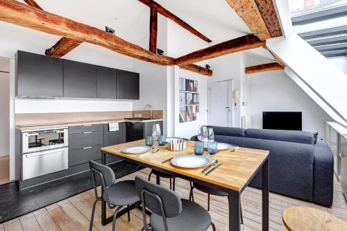 une cuisine et une salle à manger avec une table et des chaises en bois dans l'établissement Un Eclat de Lumiere en Plein Paris, à Paris