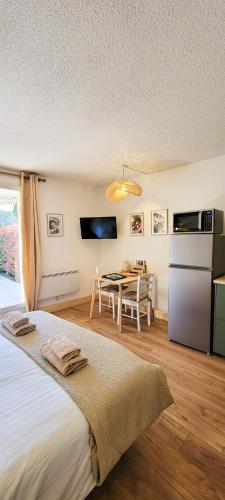 une chambre avec un lit et une table et une cuisine dans l'établissement Sous le tilleul, à Gréoux-les-Bains