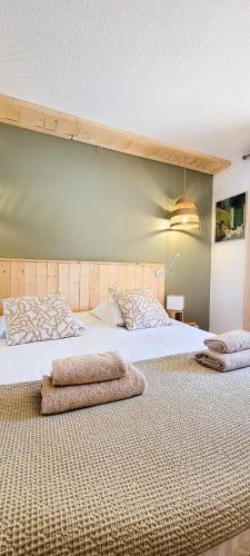 un grand lit avec deux oreillers dessus dans l'établissement Sous le tilleul, à Gréoux-les-Bains