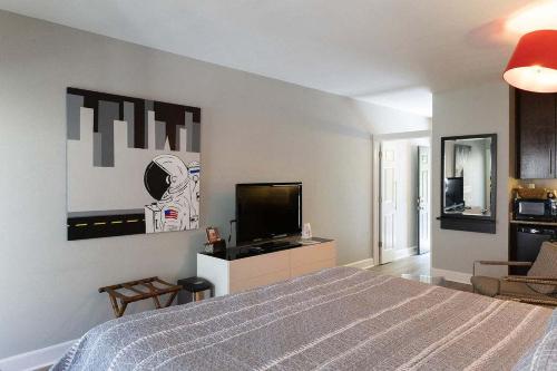 a bedroom with a bed and a flat screen tv at Bella Paradiso 13 King Bed Studio Walk to Downton in Eureka Springs