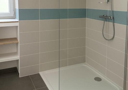 a shower with a glass door in a bathroom at Chambre d'hôtes Caussenarde in Le Massegros