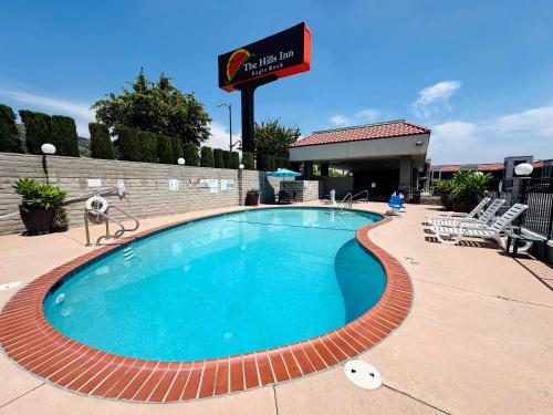 a swimming pool at a hotel with a sign at The Hills Inn Eagle Rock - Near Old Town Pasadena in Los Angeles