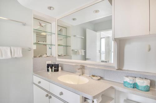 a bathroom with a sink and a mirror at Steps to the Beach! Gorgeous Ocean-View Condo with Complimentary Parking (12508) in Honolulu