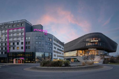 a large building with a pink sign on top of it at Moxy Southampton in Southampton