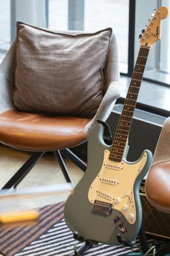 a guitar sitting on a chair next to a chair at Moxy Southampton in Southampton