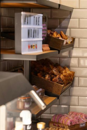a bakery with three shelves of pastries and breads at Moxy Southampton in Southampton