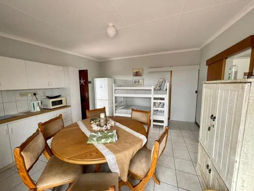 a kitchen with a wooden table and chairs in a room at Bayview Seefront Accommodation in Mossel Bay