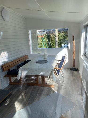 a dining room with a table and a window at Charming Cottage in Räng Sand in Höllviken