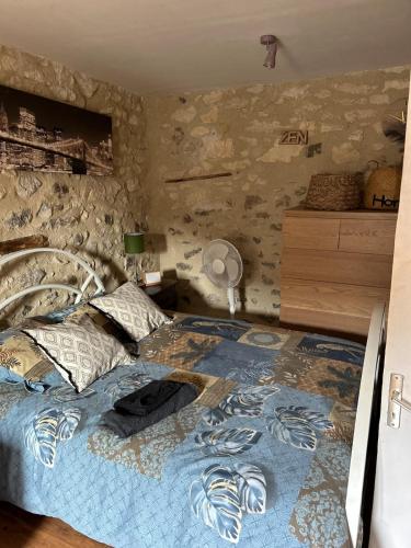 une chambre avec un lit avec un mur en pierre dans l'établissement Maison de village typique, à Meysse