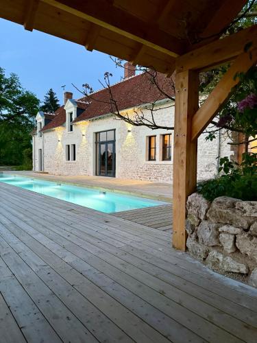 une maison avec une piscine et une terrasse en bois dans l'établissement Au Détour des Châteaux, à Méhers
