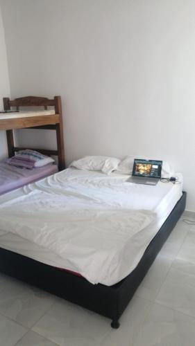 ein Bett mit einem Laptop darauf in der Unterkunft Curinca in Santa Marta