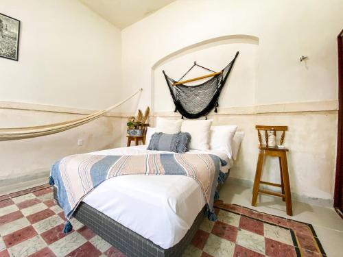 a bedroom with a bed with a hammock on the wall at Gorgeous and Equipped 3BR Villa With Private Pool and Patio in Mérida