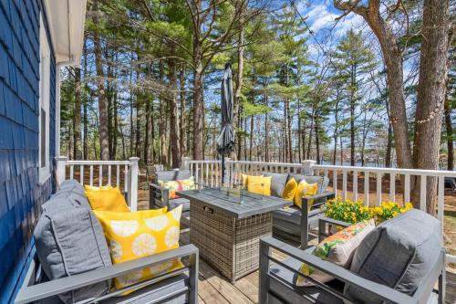 a patio with two chairs and a table on a deck at Breathtaking Riverfront Hideaway in Wareham in Wareham