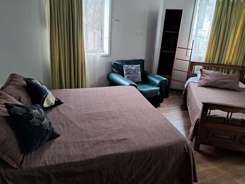 a hotel room with a bed and a chair at Hostal Puerto Lounge in Valparaíso
