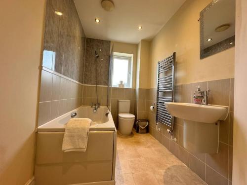 un bagno con vasca, lavandino e WC di Modern Escape with Hot Tub 4 Car Parking a Peterborough