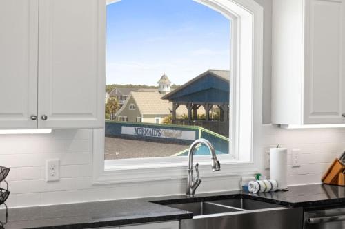 eine Küche mit einem Waschbecken und ein Fenster mit Aussicht in der Unterkunft Hypnotic your seaside retreat in Holden Beach