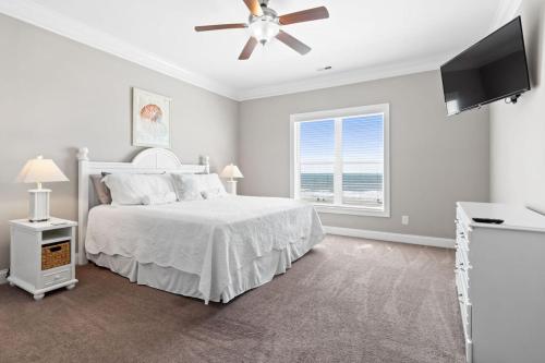 Schlafzimmer mit einem Bett, einem Deckenventilator und einem Fenster in der Unterkunft Hypnotic your seaside retreat in Holden Beach