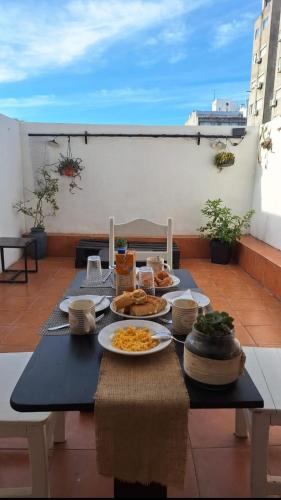 a table with plates of food on a balcony at Monoambiente céntrico in Montevideo